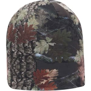 A reversible camo beanie featuring a mix of green and brown foliage patterns against a dark background.