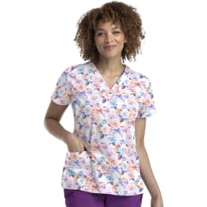 A floral women's V-neck top featuring shades of pink, purple, and blue, with a pocket and a logo.