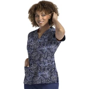 A women's V-neck print top featuring a navy background with a floral pattern in shades of blue and white. It has a logo.