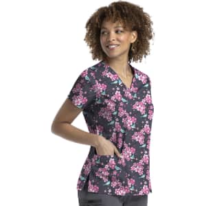 A floral printed curved V-neck top in shades of pink and black, featuring short sleeves and pockets.