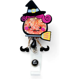 A colourful badge featuring a whimsical witch character with pink hair, a broom, and sparkling details, attached to a clip.