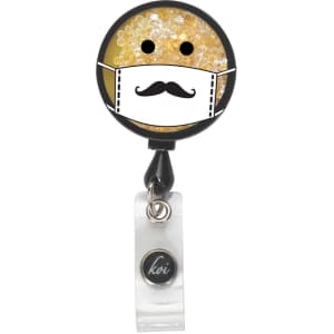 A round badge featuring a yellow, glittery design with a mask and a moustache, attached to a retractable clip.