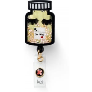A shaker badge designed as a prescription bottle, featuring decorative eyelashes and embellishments in yellow and black.