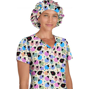 A bouffant cap featuring a colourful pattern of sheep on a light background, worn by a person in a matching top.