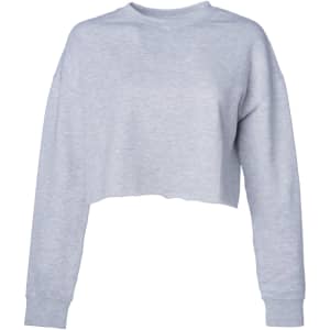 A women's cropped crew sweatshirt in light grey, featuring long sleeves and a relaxed fit. It has a logo on it.