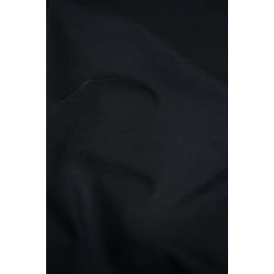 A close-up of a textured black fabric, showcasing its smooth and soft material. The image features subtle folds and shadows.