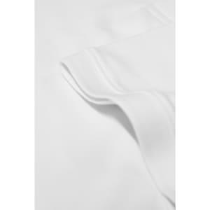 A close-up of a white polo shirt, featuring the fabric texture and a folded collar. The shirt has a logo.
