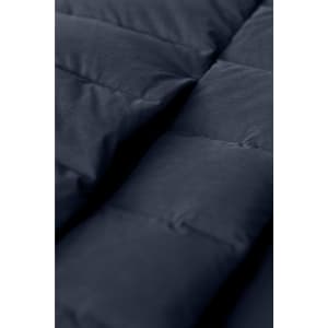 A close-up of a navy blue down jacket, featuring quilted panels and a soft texture. The image displays the jacket's padding.