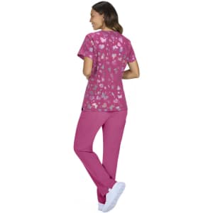 A pink scrubs set featuring a heart-patterned top and solid pink pants, paired with white footwear.