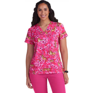 A pink floral scrub top featuring short sleeves, v-neckline, and a vibrant floral pattern.