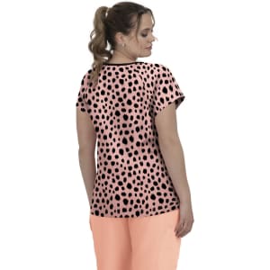 A top featuring a pink base with black spotted print, worn by a model facing away. The design includes short sleeves.