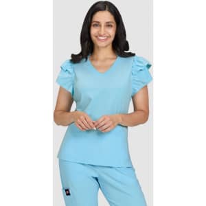 A blue medical top with ruffled sleeves, featuring a V-neck and a relaxed fit. The model is smiling.
