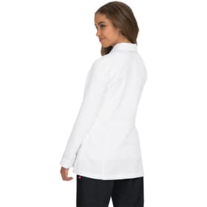A white lab coat with a tailored fit, featuring a collar and a logo on the back, modeled by a woman.