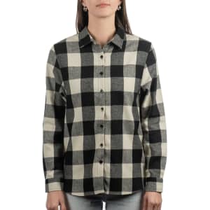 A button-up flannel shirt in black and cream plaid with a collar and long sleeves. The shirt has a logo.
