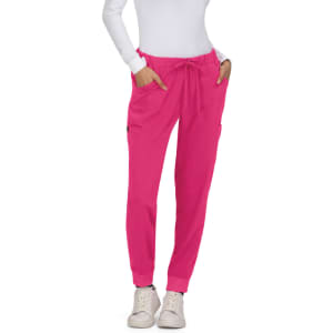 Bright pink Aster Pants with pockets, worn by a model in a white top and casual shoes.