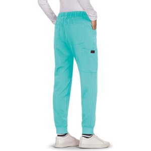 A pair of turquoise pants with a relaxed fit, featuring pockets and worn with white shoes.