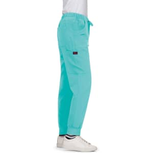 Turquoise Aster Pants displayed on a model, featuring a loose fit and cargo pockets. The model wears white shoes.