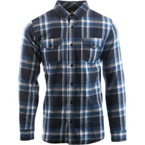 A blue and white plaid flannel shirt is displayed on a model from the side, featuring rolled-up sleeves and a logo.