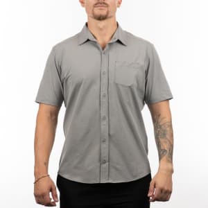 A short sleeve shirt in grey, featuring a button-up front and a chest pocket, displayed on a model.