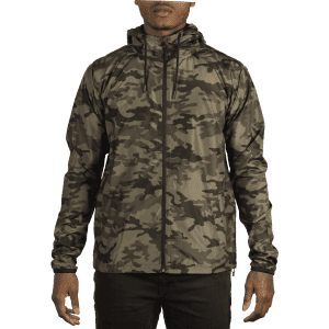 A lightweight windbreaker in a camouflage pattern, featuring a hood and zippered front. The jacket is shown on a model.