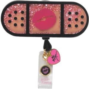 A retractable badge holder featuring a pink glitter design with a kiss motif and decorative charms in black and pink.