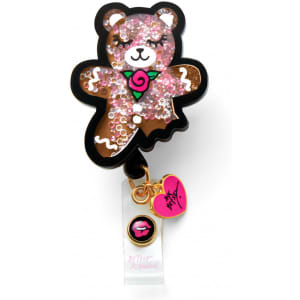 A cute, glittery gingerbread bear badge in brown and pink, featuring a heart-shaped charm and a logo.