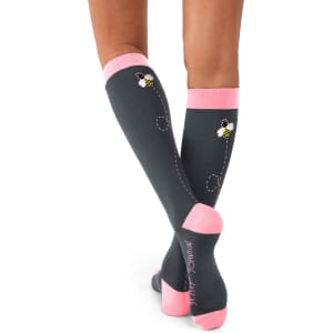 Compression socks in grey with pink accents, featuring a bee design on the back and a logo. Two pairs included.