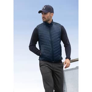 A navy blue men's vest with a quilted design, featuring a zip and side pockets, worn with a black long-sleeve top and cap.