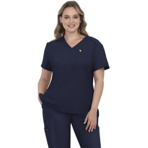 A navy blue scrub top featuring a V-neck design and a small logo. The model stands with hands on hips.