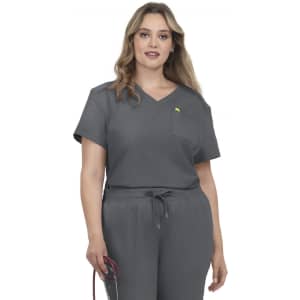 A woman wearing grey scrubs with a pocket and a yellow logo, holding a stethoscope.