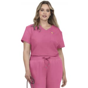 A pink scrub top with a short sleeve design and a chest pocket, worn by a model holding a medical stethoscope.