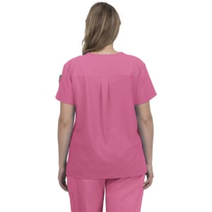 A pink scrub top with a back pleat, designed for comfort and style, featuring a logo on the sleeve.