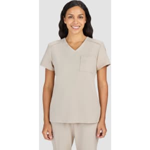 A scrub top in a light beige colour, featuring a V-neck and a single chest pocket. It has branding on the sleeve.