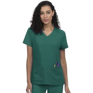 A scrub top in teal green featuring two front pockets and a V-neck design. The model has curly hair and wears it confidently.