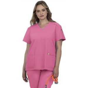A pink scrub top with a V-neck design and two front pockets, worn by a model. The product features a logo.