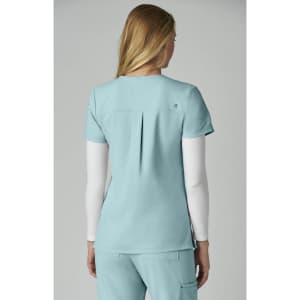A dress top in light blue with a pleated back, featuring a small logo on the upper section.
