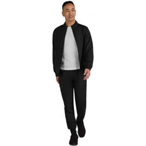 A black men's jacket is worn over a grey top, paired with matching black pants and shoes. The model is walking.