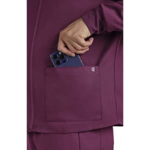 A maroon jacket with a pocket, featuring a hand placing a smartphone into it. The jacket has a logo.