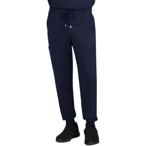A pair of navy joggers featuring an elastic waistband and side pockets, worn with black shoes.