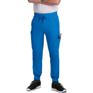 A pair of blue jogger pants featuring side pockets, worn by a person in a white t-shirt and black shoes.