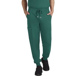 A pair of green jogger pants featuring pockets and an elastic waistband, worn by a person standing casually.