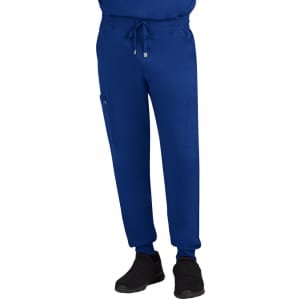 A pair of blue joggers featuring side pockets and an elastic waistband, worn with black shoes.