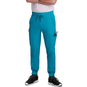 A pair of teal jogger pants with pockets, featuring a drawstring waist, worn with black shoes.