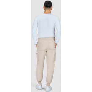 A person in a white top is wearing beige jogger pants with pockets, viewed from the back.