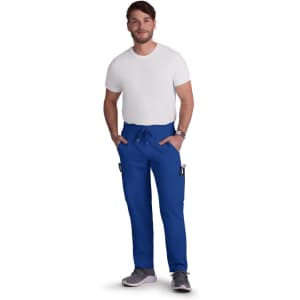 A man wearing bright blue cargo pants with pockets, standing casually with hands in pockets, and wearing a white t-shirt.