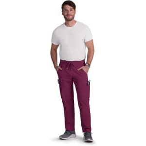 A man wearing burgundy Neuro Cargo Pants with pockets, paired with a white t-shirt and grey shoes. The product has a logo.