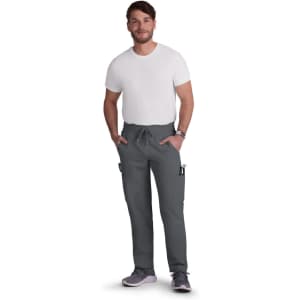 A man wearing grey cargo pants with pockets, paired with a plain white t-shirt and grey shoes.
