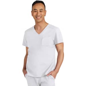 A man wearing a light grey scrub top with a V-neck and a pocket on the chest, smiling towards the camera.