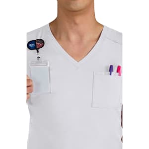 A white V-neck shirt with two pockets, one containing pens and a name badge holder.