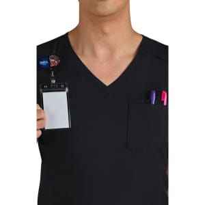 A person wearing a black v-neck scrubs top, featuring a pocket with two pens and a name badge holder.